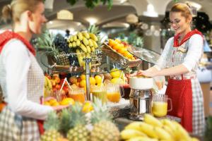 un hombre y una mujer de pie en una cocina preparando fruta en Landzeit Motor-Hotel St. Valentin en Sankt Valentin