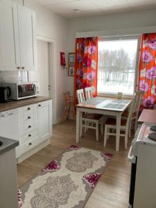 a kitchen with a table and a dining room at Suutalan Mansikkatalo in Ylipää