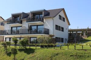 ein Apartmenthaus mit Bäumen davor in der Unterkunft Reblandhof Siebenhaller in Immenstaad am Bodensee