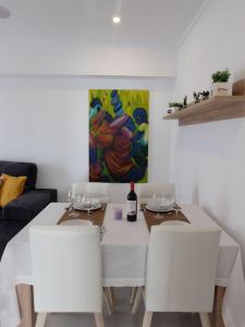 une table à manger blanche avec des chaises blanches et un tableau dans l'établissement BonaMar I - 2A, à Son Servera