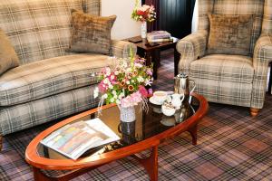 a living room with couches and a table with flowers on it at The Lagg in Lagg