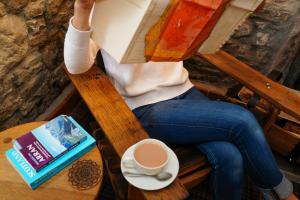 a person sitting in a chair with a cup of coffee at The Lagg in Lagg