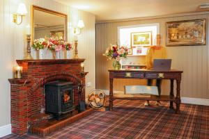 a living room with a brick fireplace and a mirror at The Lagg in Lagg