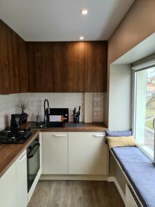 a kitchen with white cabinets and a window at West coast apartments in Klaipėda