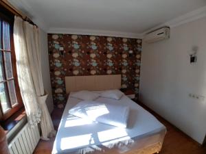A bed or beds in a room at Konak Hotel Tuzla