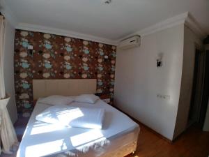 A bed or beds in a room at Konak Hotel Tuzla