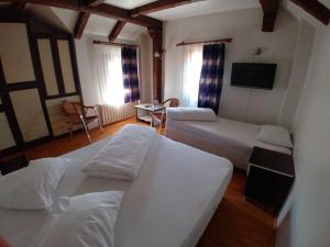 A bed or beds in a room at Konak Hotel Tuzla