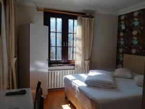A bed or beds in a room at Konak Hotel Tuzla
