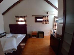 A bed or beds in a room at Konak Hotel Tuzla