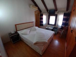 A bed or beds in a room at Konak Hotel Tuzla