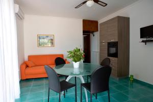 a living room with a table and chairs and an orange couch at L'Ulivo Sul Mare in Cetraro