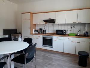 a kitchen with white cabinets and a table and chairs at Monteurhaus Scheidter 42 in Saarbrücken