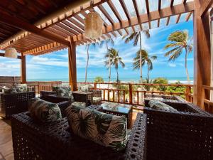 a patio with chairs and a view of the ocean at Pousada Janelas do Mar in Flecheiras