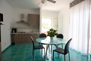 a kitchen with a glass table and chairs in a room at L'Ulivo Sul Mare in Cetraro