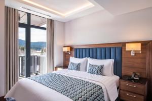 Postel nebo postele na pokoji v ubytování Ambassadori Goderdzi Hotel