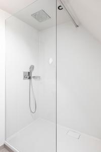 una doccia con porta in vetro e soffione di Salons Denotter a Zedelgem