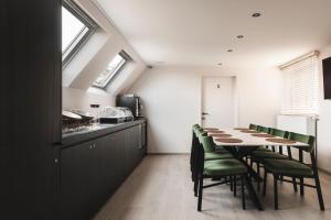 a dining room with a long table and green chairs at Salons Denotter in Zedelgem