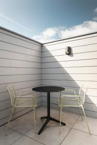 - une table et deux chaises sur la terrasse dans l'établissement Salons Denotter, à Zedelgem