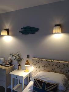 1 dormitorio con 1 cama y 2 luces en la pared en Old Borough Arms en Rye