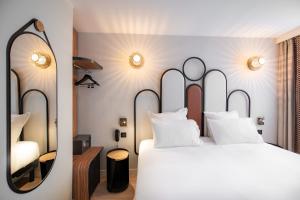 a bedroom with a large bed and a mirror at Hôtel de L'Esperance in Paris