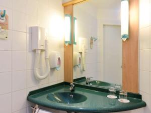 a bathroom with two sinks and a mirror at Ibis Budapest City in Budapest