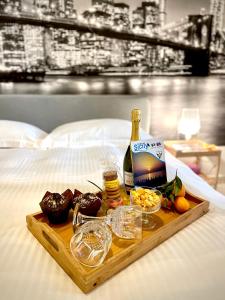 een dienblad met eten en een fles wijn op een bed bij The Place in Terrasini