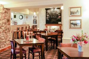 a restaurant with wooden tables and chairs and flowers at The Lagg in Lagg