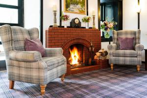 a living room with two chairs and a fireplace at The Lagg in Lagg