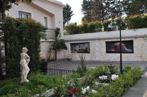 a statue in a garden in front of a house at Agri Art Croce Vallone in Biancavilla