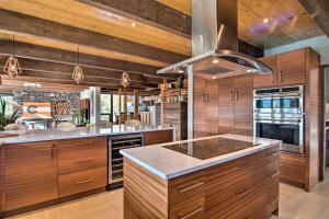 een keuken met houten kasten en een fornuis met oven bij Chic Boulder Mountain Home with Hot Tub and Views in Boulder