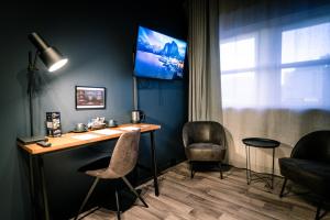 a room with a desk and two chairs and a tv at Canyon Hotell in Alta