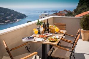 a table with food and drinks on a balcony at Luxury Apartment Edi in Dubrovnik