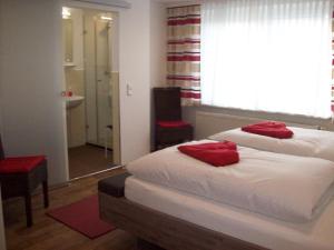 Un dormitorio con una cama con almohadas rojas. en Ferienhaus Isolde, en Bodenmais