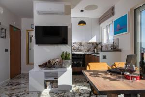 uma sala de estar com uma mesa e uma televisão na parede em Luxury Apartment Edi em Dubrovnik