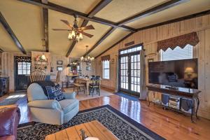a living room with a tv and a couch and a table at Cozy Caymus Cabin about 3 Miles to Callaway Gardens! in Pine Mountain