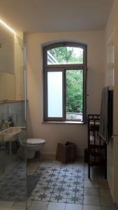 La salle de bains est pourvue d'un lavabo, de toilettes et d'une fenêtre. dans l'établissement Ferienwohnungen Strauß am Botanischen Garten in Eschwege, à Eschwege
