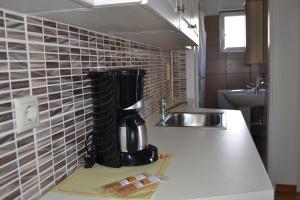 a kitchen with a coffee maker on a counter next to a sink at Rivitel Marousi Apartments in Athens +74 photos