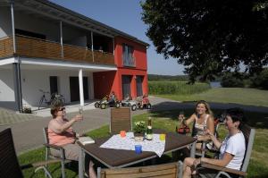 a group of people sitting at a table in front of a house at Feriendomizil Carmen Hofmann in Absberg