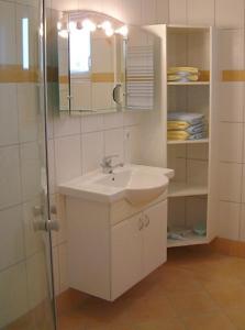 a white bathroom with a sink and a mirror at Feriendomizil Carmen Hofmann in Absberg +24 photos