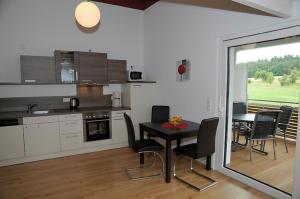 a kitchen and dining room with a table and chairs at Feriendomizil Carmen Hofmann in Absberg