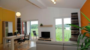 a living room with a couch and a table with a television at Feriendomizil Carmen Hofmann in Absberg
