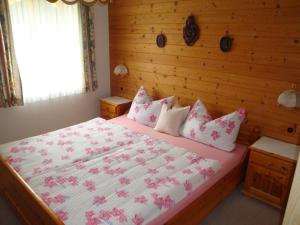 a bedroom with a large bed with pink sheets and pillows at Haus Elisabeth in Unterwössen