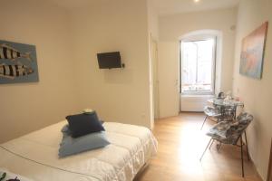 a bedroom with a bed and a table and a window at vernazza vacation 3 in Vernazza