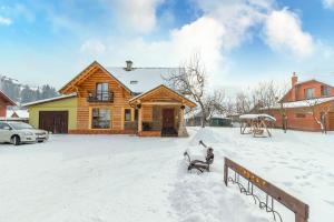 a house with a snow covered porch and a fire hydrant at Kovalska Sadyba in Slavske