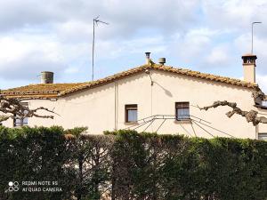 a white house with a roof at Casa Rural "Can Abres" Vilobi d`Onyar Girona in Vilobí d'Onyar