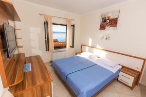 a bedroom with a blue bed and a television at Pansion Croatia in Starigrad