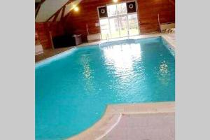 una grande piscina blu in un edificio di Bulle d'évasion Aux portes de Honfleur - Piscine couverte a Boulleville
