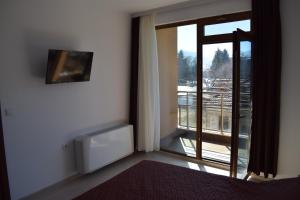 a room with a window with a view of a balcony at Къща за гости Шошови in Velingrad