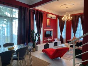 a living room with red walls and a table and chairs at Pasir Gudang Marissa Homestay in Masai