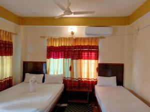 2 camas en una habitación con ventana en Hotel Greenlight, en Chitwan